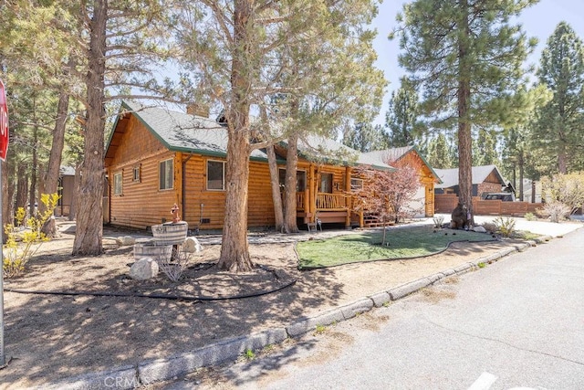 view of front of property featuring a chimney and log veneer siding