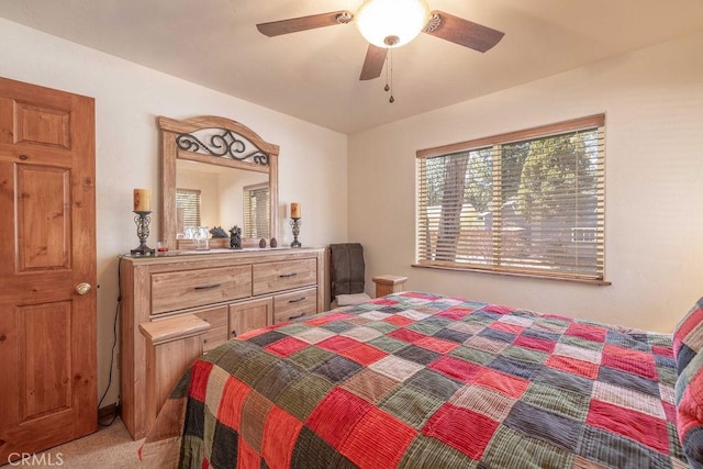 bedroom featuring light carpet, a ceiling fan, and multiple windows