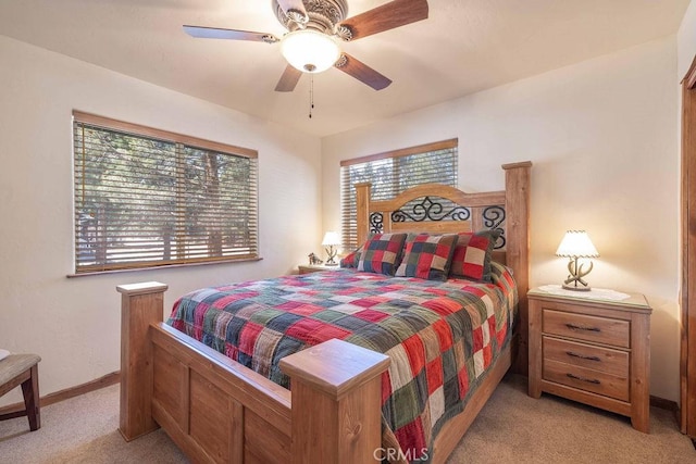 bedroom featuring light carpet, baseboards, and a ceiling fan