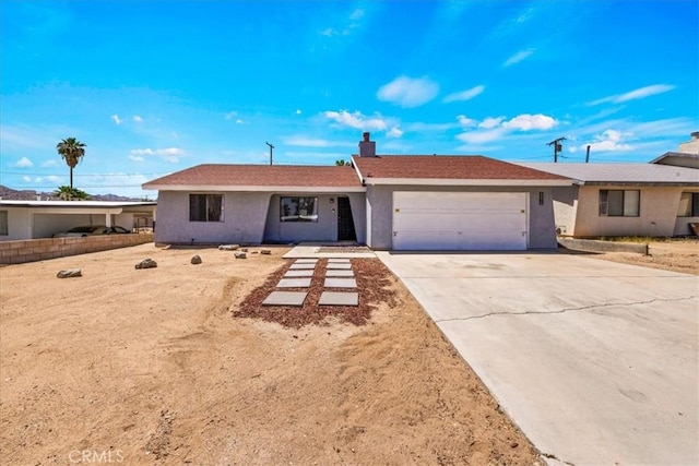 single story home featuring a garage, stucco siding, a chimney, and driveway