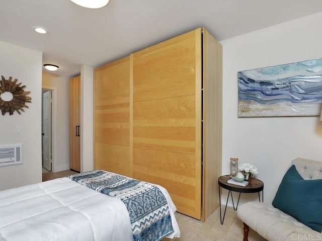 bedroom featuring light colored carpet and an AC wall unit