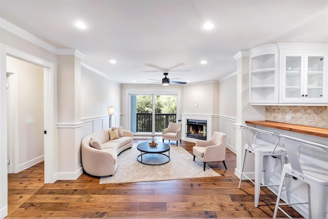 3527 Caminito Sierra Unit 202, Carlsbad, CA 92009 - living room with a ceiling fan, ornamental molding, wood-type flooring, a decorative wall, and wainscoting