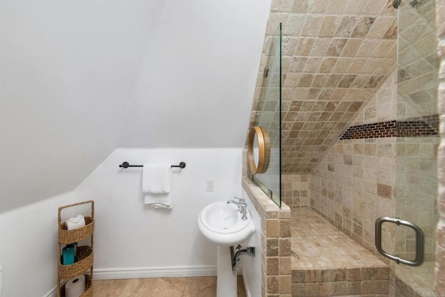 bathroom featuring lofted ceiling and a shower stall