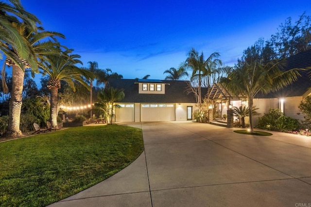 view of front facade featuring concrete driveway and a front yard