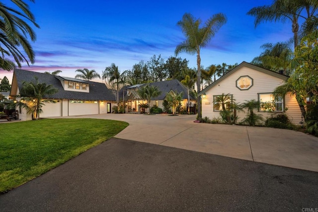 view of front of property featuring a garage, a front yard, and driveway