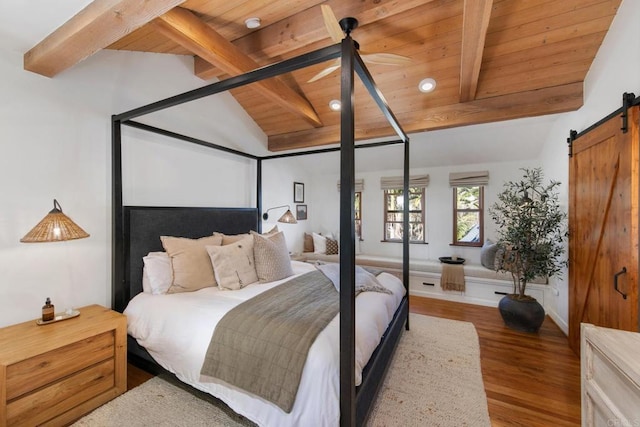 bedroom with wood finished floors, lofted ceiling with beams, baseboards, a barn door, and wooden ceiling