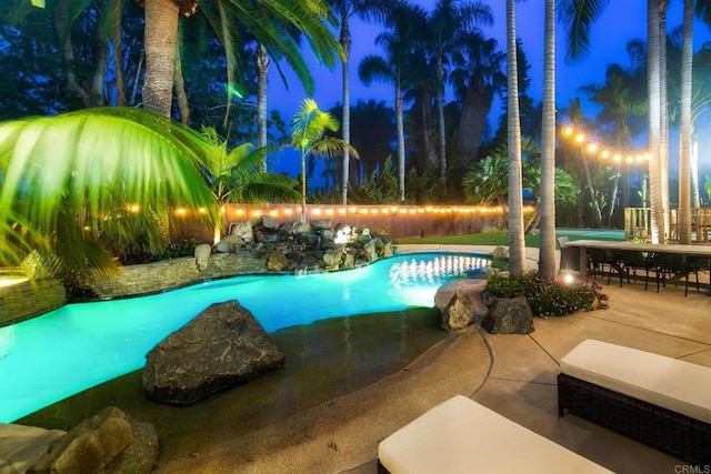 pool at twilight featuring a patio and a fenced in pool