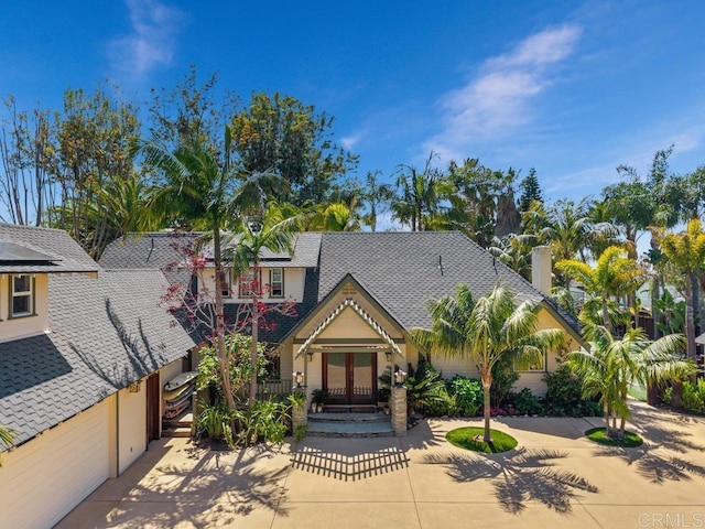 view of front of property featuring french doors and a shingled roof