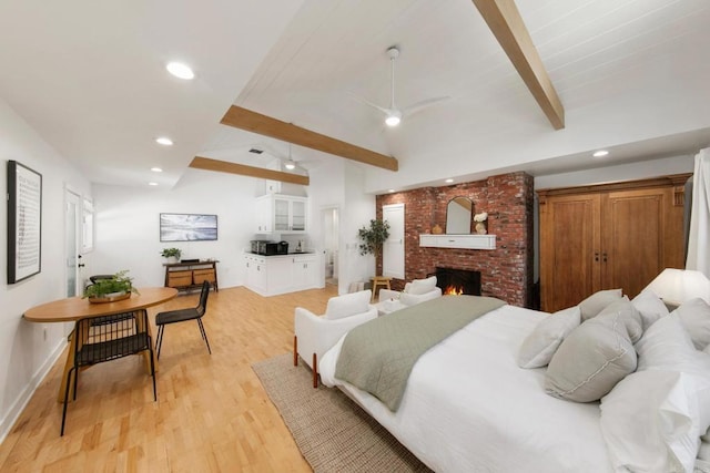 bedroom with light wood-style flooring, recessed lighting, baseboards, lofted ceiling with beams, and a fireplace