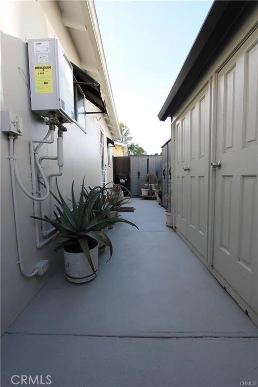 view of patio / terrace featuring tankless water heater and fence