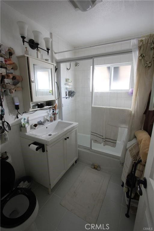 full bathroom with tile patterned flooring, toilet, a wealth of natural light, and vanity