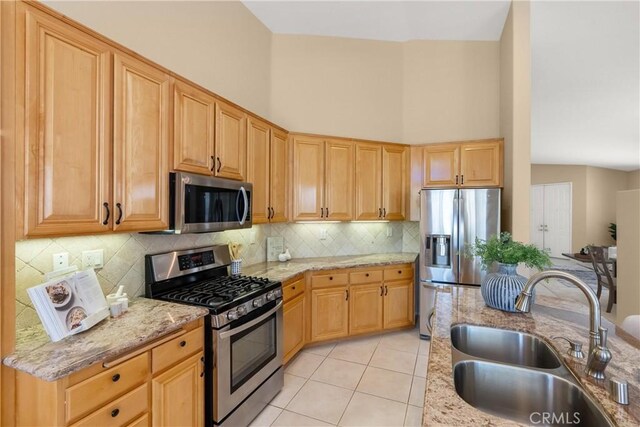40050 Corte Fortuna, Murrieta, CA 92562 - kitchen with a sink, stainless steel appliances, light tile patterned flooring, backsplash, and light stone countertops