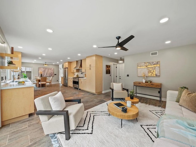 living room with baseboards, a ceiling fan, visible vents, and recessed lighting