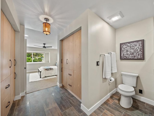 ensuite bathroom featuring ensuite bath, baseboards, toilet, and ceiling fan