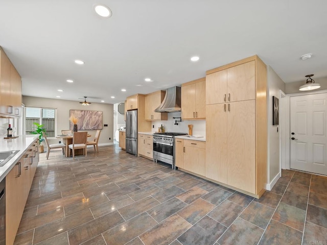 kitchen with wall chimney exhaust hood, light countertops, light brown cabinets, baseboards, and appliances with stainless steel finishes
