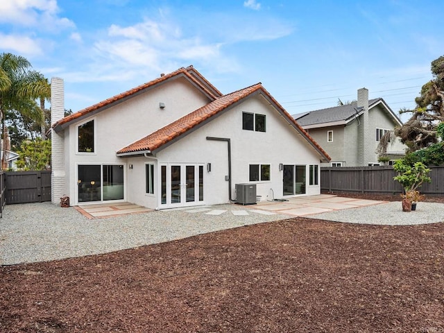 back of property with a fenced backyard, a patio area, stucco siding, and french doors