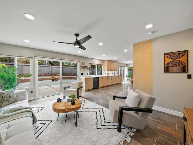 living room featuring ceiling fan, baseboards, and recessed lighting