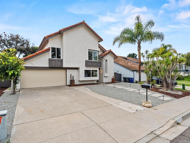 view of front of house with concrete driveway, a garage, stucco siding, and a tiled roof