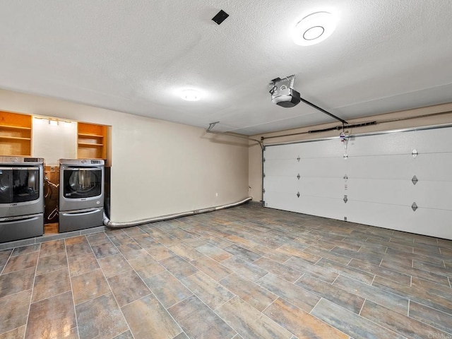 garage with washing machine and dryer and a garage door opener