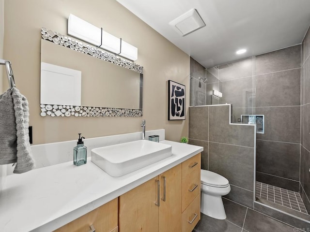 bathroom with toilet, tile patterned flooring, vanity, and a walk in shower