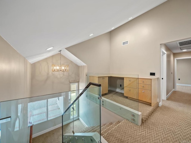 hall with light carpet, lofted ceiling, and visible vents