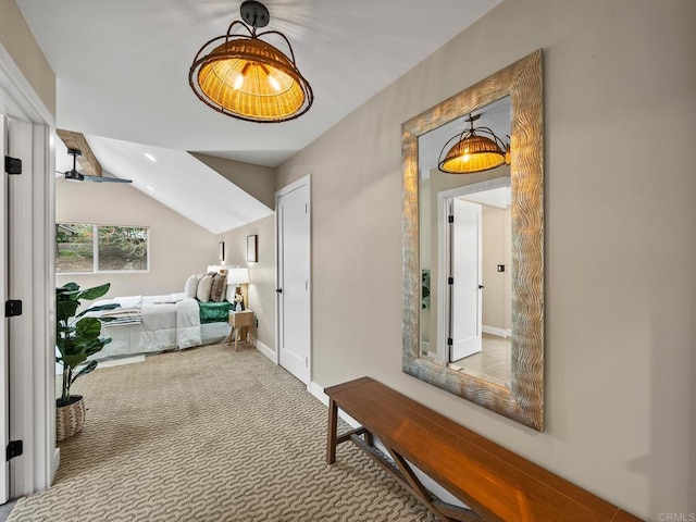 hall with vaulted ceiling, baseboards, and carpet floors