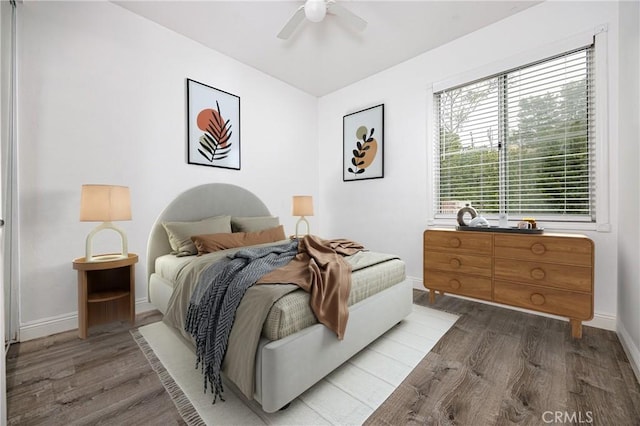 bedroom featuring wood finished floors, baseboards, and ceiling fan