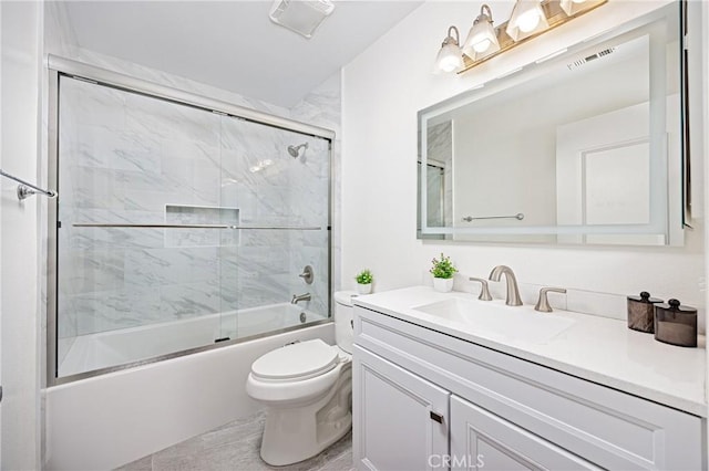 bathroom featuring vanity, shower / bath combination with glass door, and toilet