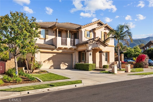 mediterranean / spanish-style home featuring a balcony, a tiled roof, driveway, a garage, and stucco siding