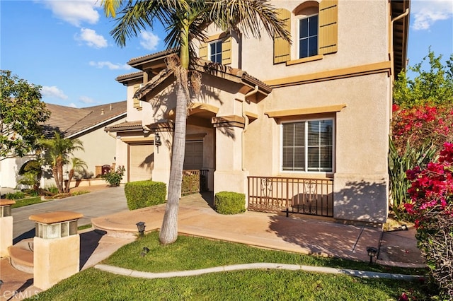 view of front facade featuring stucco siding, driveway, and a garage