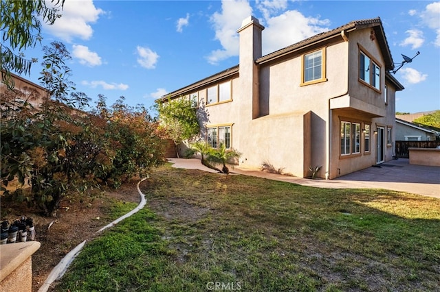 11151 Tesota Loop St, Corona, CA 92883 - rear view of property featuring a chimney, stucco siding, and a patio area