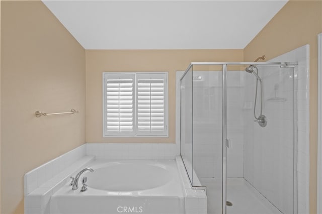bathroom featuring a stall shower and a garden tub
