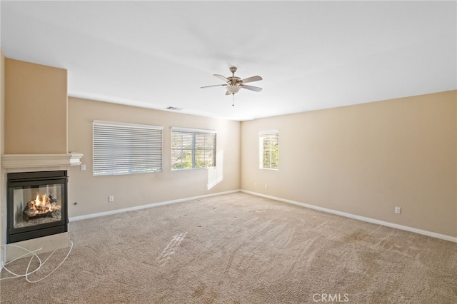 11151 Tesota Loop St, Corona, CA 92883 - unfurnished living room featuring a ceiling fan, a multi sided fireplace, carpet flooring, and baseboards