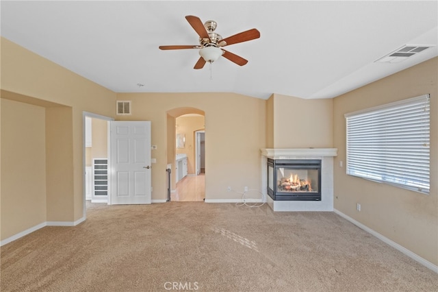 11151 Tesota Loop St, Corona, CA 92883 - unfurnished living room with arched walkways, carpet, a multi sided fireplace, ceiling fan, and baseboards