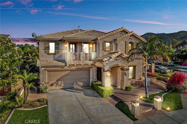 11151 Tesota Loop St, Corona, CA 92883 - mediterranean / spanish-style house with a balcony, concrete driveway, a tiled roof, a garage, and stucco siding