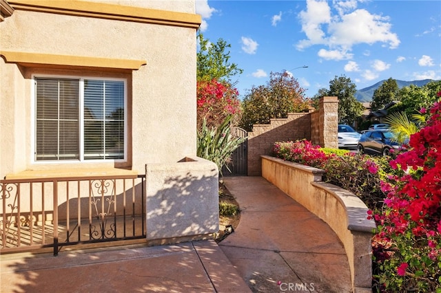 view of property exterior featuring a fenced front yard, stucco siding, and a gate
