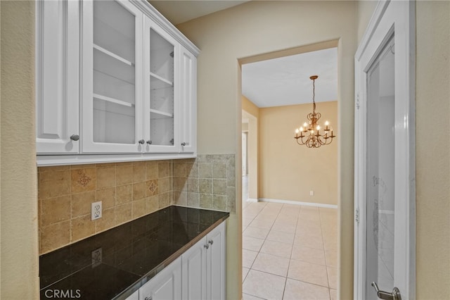 11151 Tesota Loop St, Corona, CA 92883 - kitchen with white cabinetry, light tile patterned floors, glass insert cabinets, a chandelier, and tile countertops