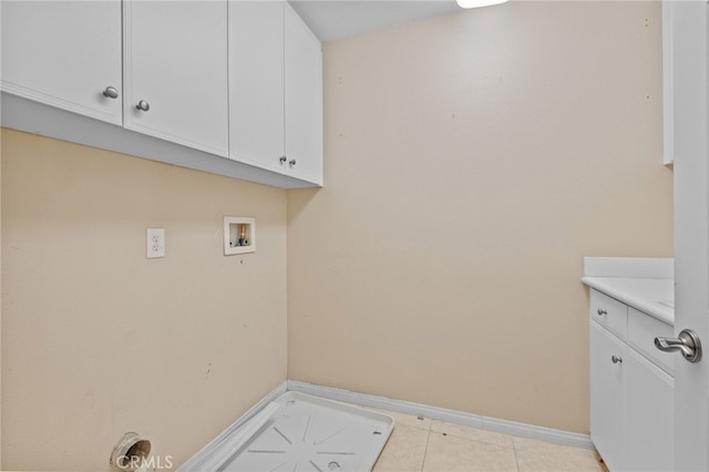 laundry area with hookup for a washing machine, light tile patterned flooring, cabinet space, and baseboards