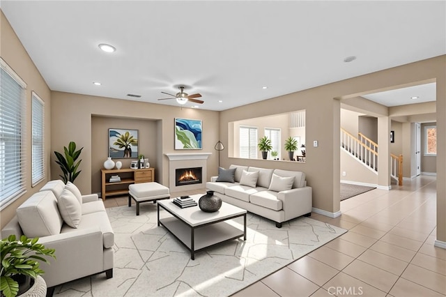 11151 Tesota Loop St, Corona, CA 92883 - living area featuring ceiling fan, stairway, a lit fireplace, baseboards, and recessed lighting