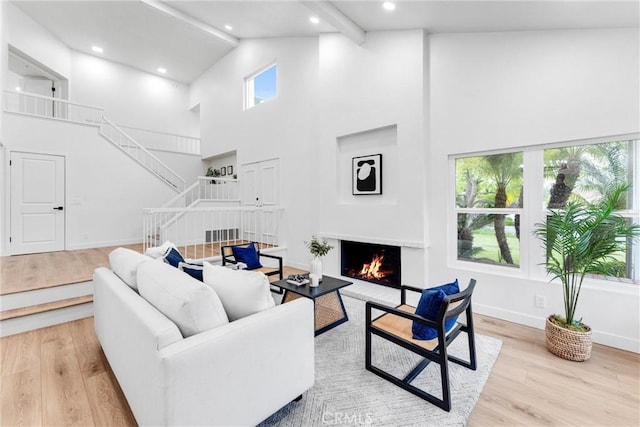 5431 Via Ontiveros, Yorba Linda, CA 92887 - living room with high vaulted ceiling, stairway, a lit fireplace, baseboards, and light wood-style floors