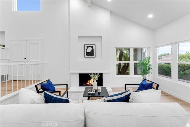 5431 Via Ontiveros, Yorba Linda, CA 92887 - living room with a warm lit fireplace, wood finished floors, high vaulted ceiling, recessed lighting, and baseboards