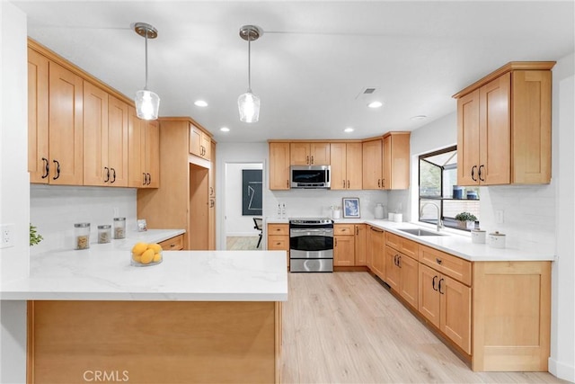 5431 Via Ontiveros, Yorba Linda, CA 92887 - kitchen featuring a peninsula, hanging light fixtures, a sink, stainless steel appliances, and light wood-style floors