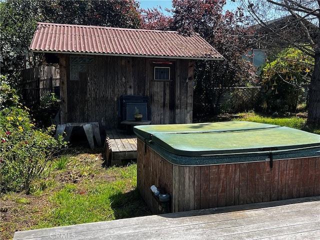 view of yard featuring a hot tub, an outdoor structure, and fence