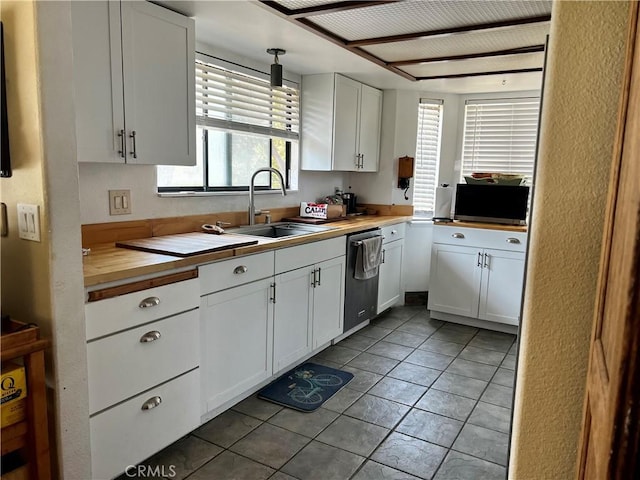 kitchen with tile patterned floors, white cabinets, a sink, and dishwasher