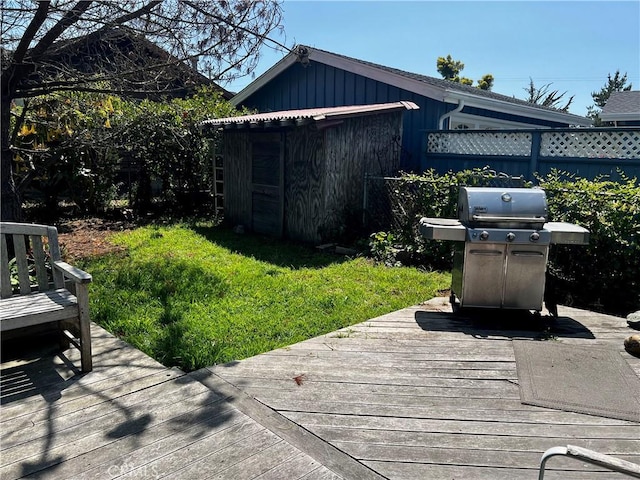 deck with grilling area, fence, and a lawn