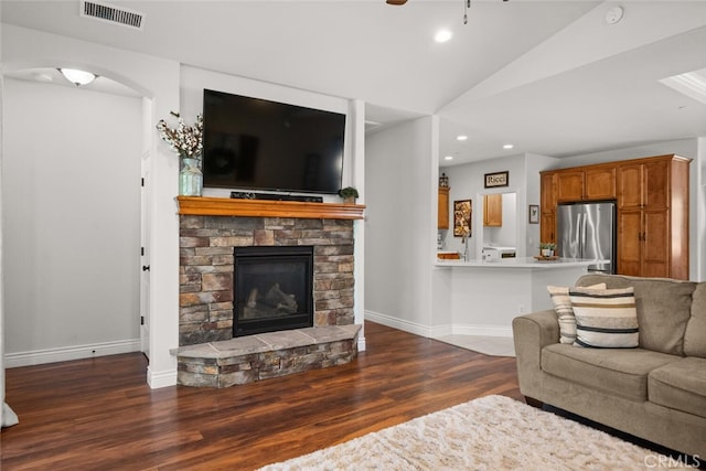 living area with recessed lighting, visible vents, vaulted ceiling, a fireplace, and wood finished floors