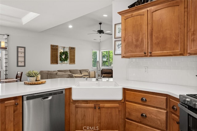kitchen featuring a ceiling fan, a sink, open floor plan, stainless steel dishwasher, and tasteful backsplash