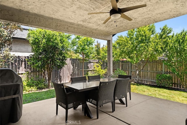 view of patio with outdoor dining area, a ceiling fan, a fenced backyard, and grilling area