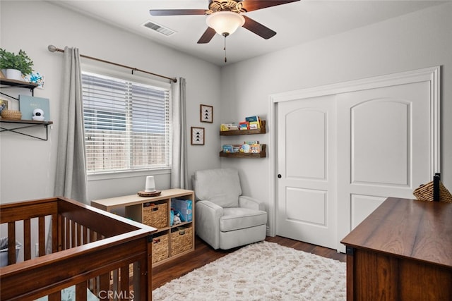 bedroom featuring ceiling fan, a closet, dark wood-style floors, and visible vents