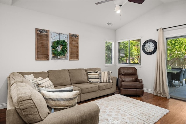 living room featuring ceiling fan, lofted ceiling, visible vents, and wood finished floors